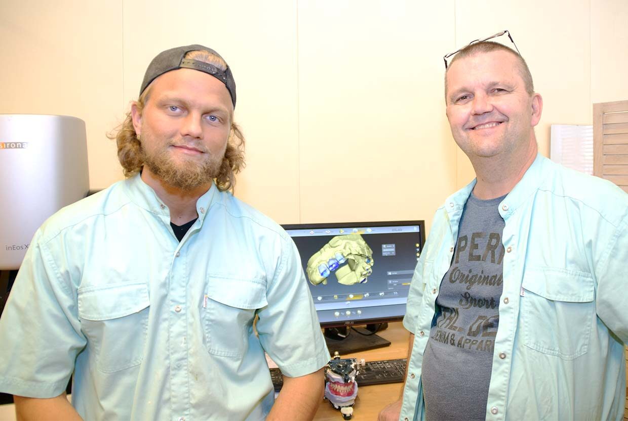 Aku ja Väinö Alapelto laboratoriossaan, taustalla skanneri ja suunnitteluohjelma näytöllä.